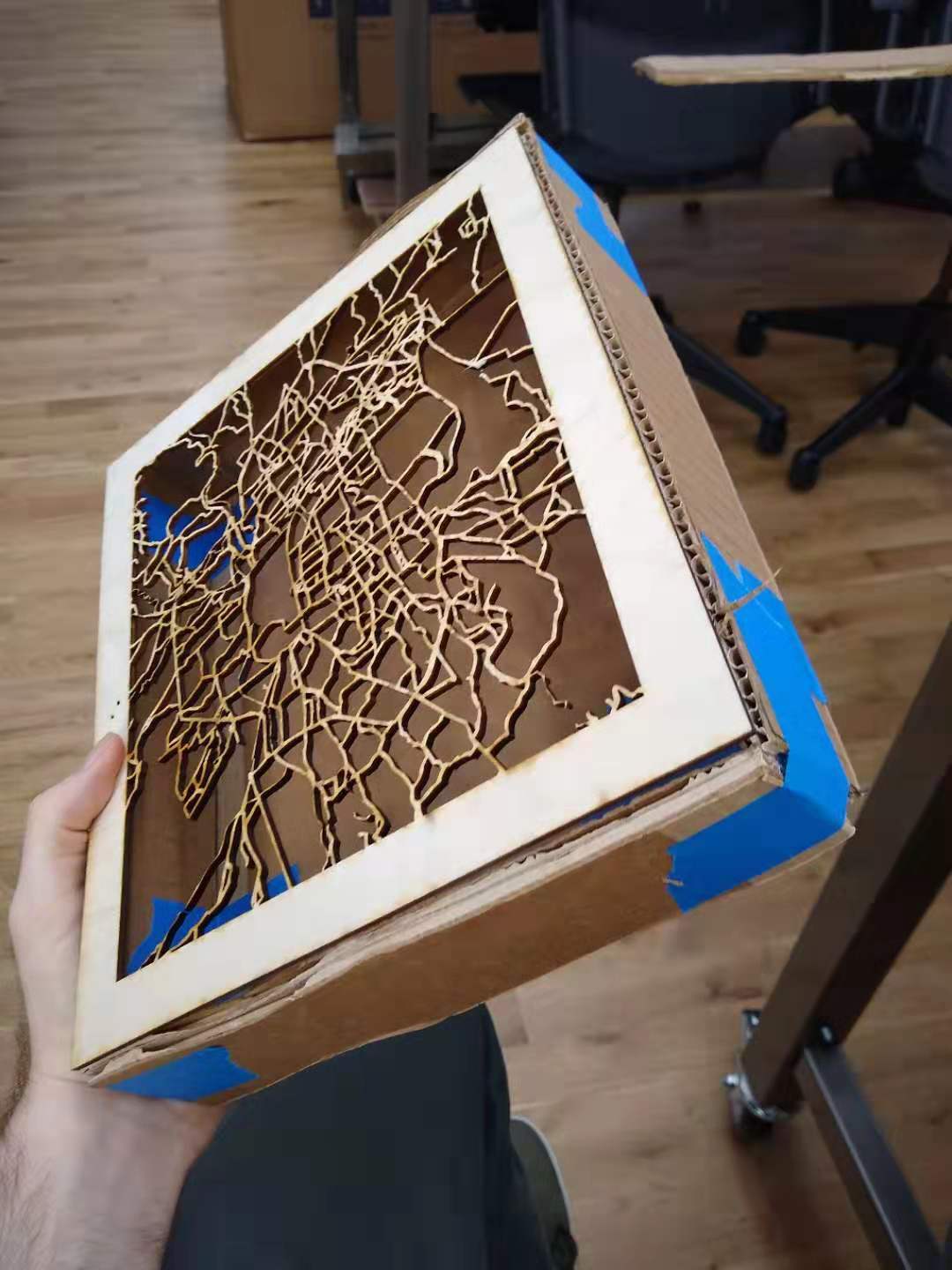 A lasercut city map on top of a cardboard box.