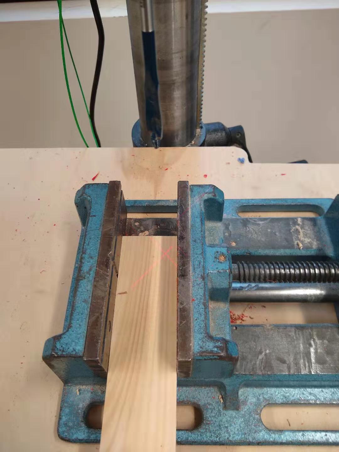 A piece of wood under the drill press.