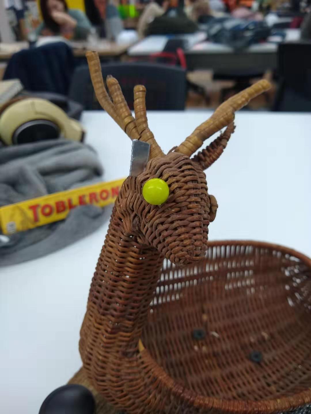 A wicker deer with an aluminum ear and tack eye.