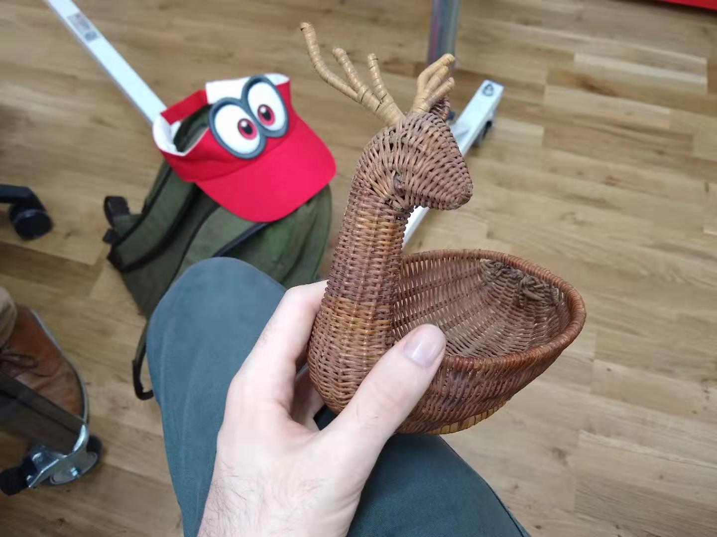A wicker deer with one eye and ear missing.