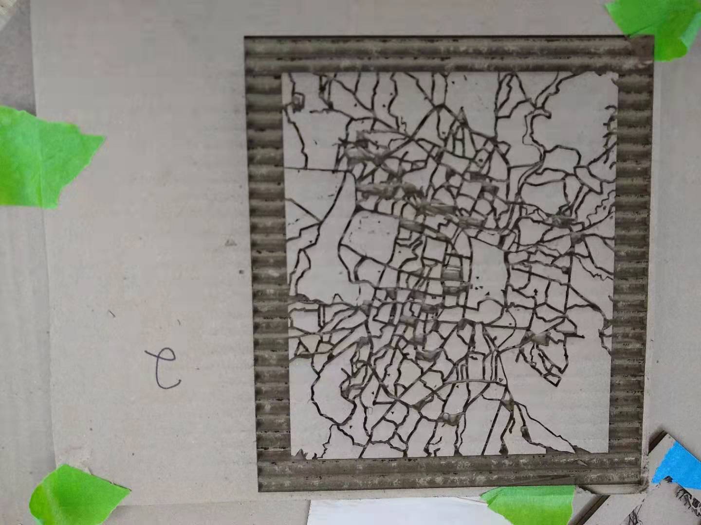 A piece of cardboard etched with a city map.