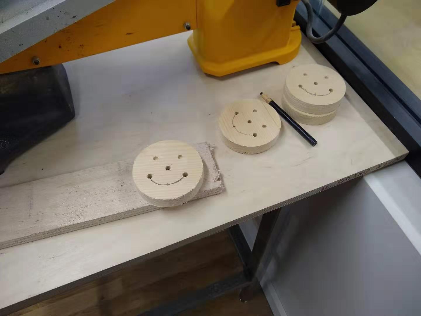 My smileys, lying near the scroll saw with
    lines drawn between the two mouth holes